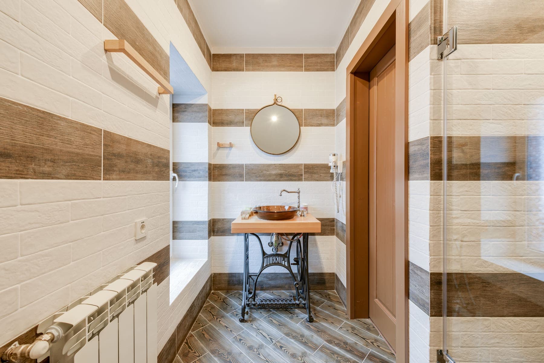 Timber vanity shelf against the banded wall tile